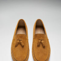 Pair of tan suede loafers shown from above, with tassels and stitched moc toes