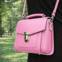Pastel pink leather crossbody handbag with front flap and metal clasp, shown at angle.