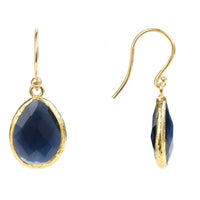 Gold drop earrings with dark blue teardrop faceted gemstones, side view