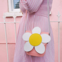Pastel pink leather barrel bag with daisy applique and crossbody strap