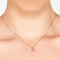 Rose gold teardrop pendant necklace with pink stone worn close to the neck