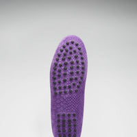 Purple loafer outsole with rows of black rubber grip studs