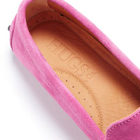 Close-up of a pink suede loafer with a tan leather insole and stitched trim.