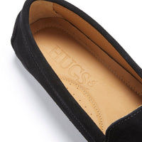 Close-up of a black suede loafer's tan leather insole and branded footbed