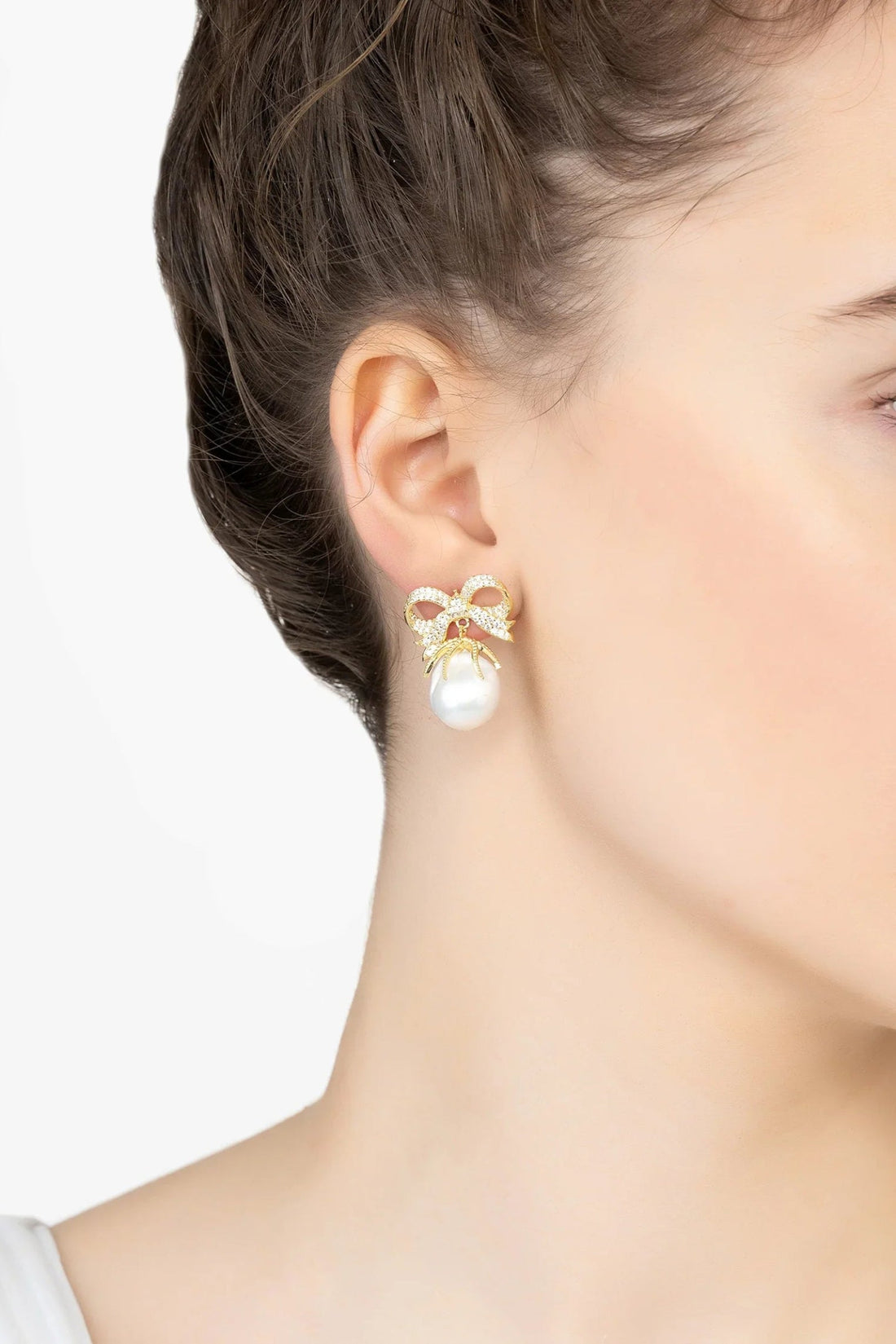 Gold ribbon bow drop earrings with white pearl, worn