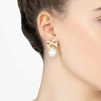Gold ribbon bow drop earrings with white pearl, worn