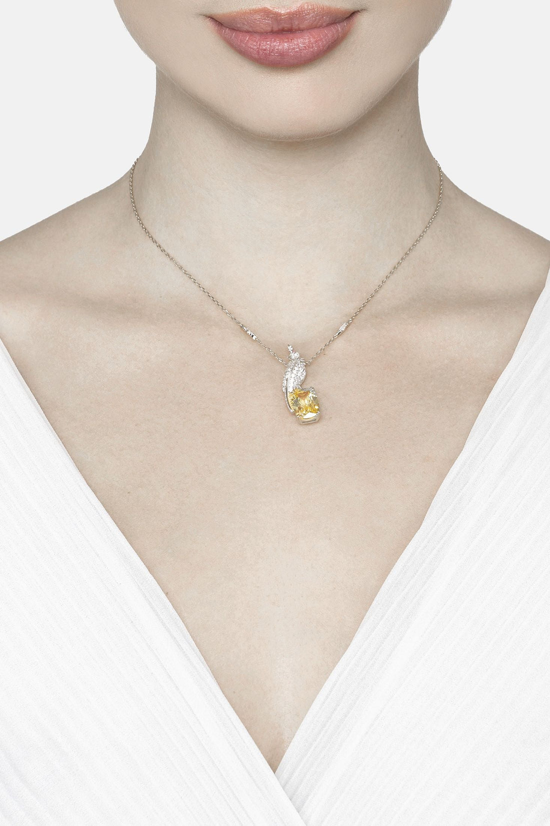 Silver chain necklace with small bird pendant and teardrop yellow gemstone