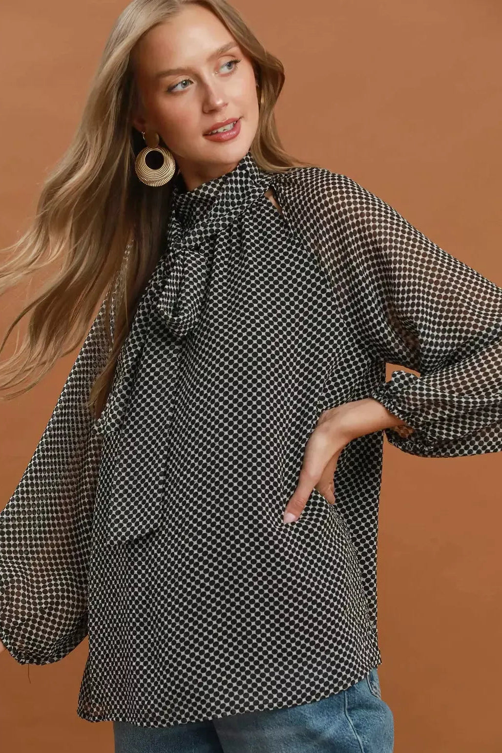 Black and white dot print tie-neck blouse with wide, draped sleeves