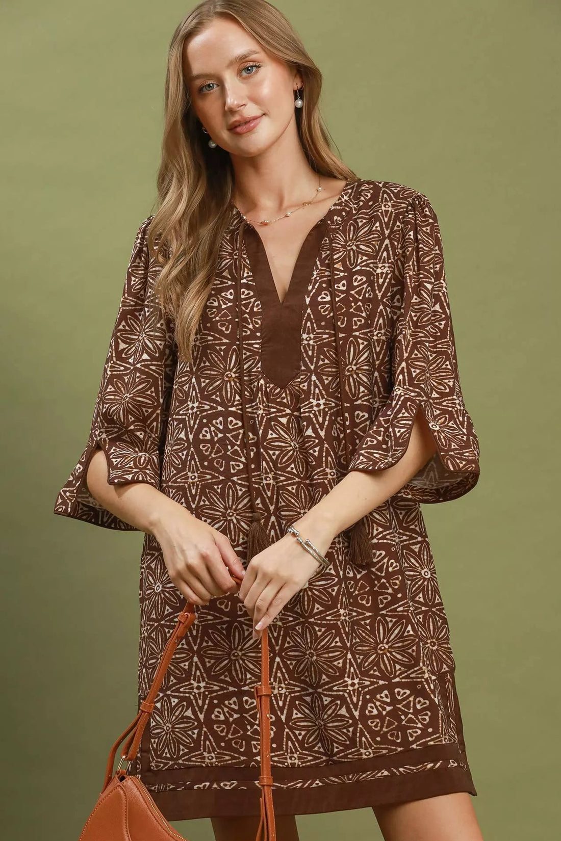 Brown geometric print tunic dress with V-neck tassel detail, flared sleeves