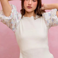 White knit sweater top with floral puff sleeves and scalloped hemline