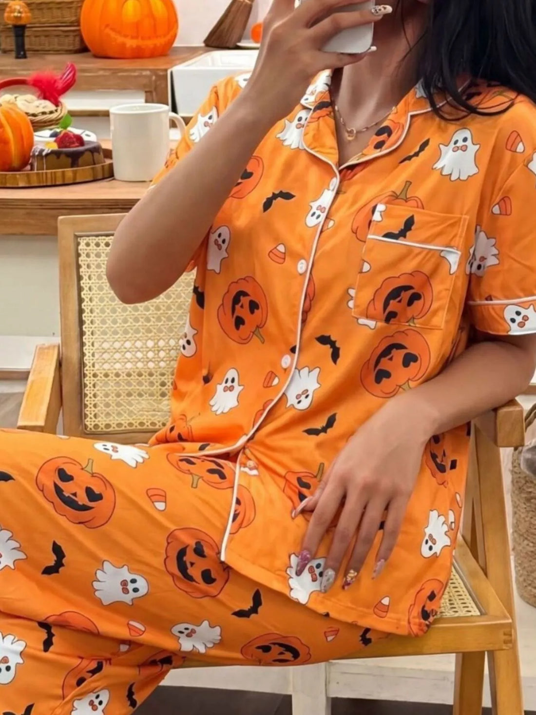 Halloween pajama set: orange button-up top and pants with pumpkin, ghost, and bat prints