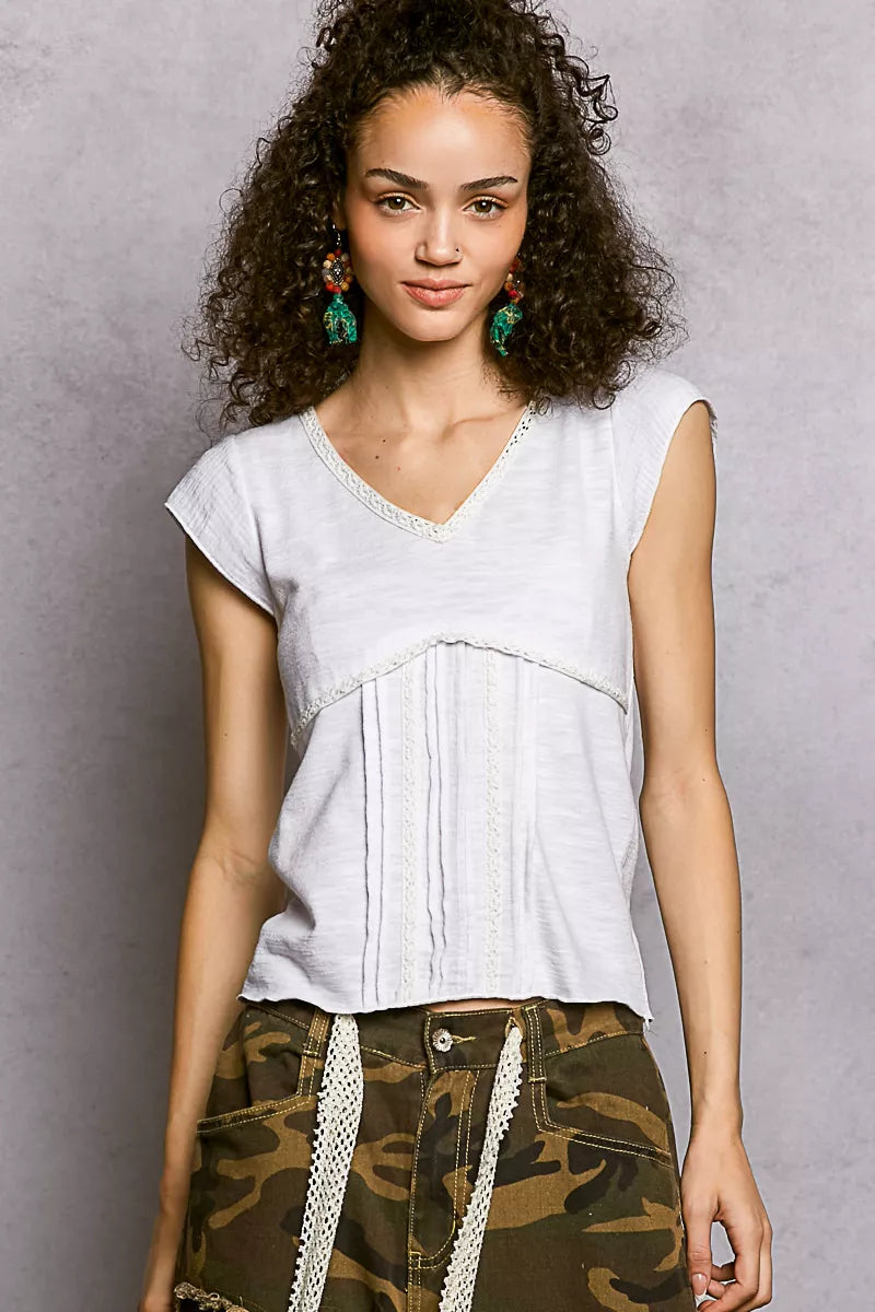 Off-white textured knit V-neck short-sleeve top with lace-trim neckline and panel