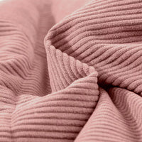 Dusty pink corduroy puffer fabric close-up with ribbed texture and stitched channel quilting.