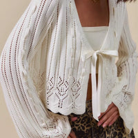 Off-white textured knit cardigan close-up, open front and ribbon bow detail