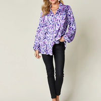 Purple printed button-up shirt with ruffle V neckline and balloon sleeves, full body