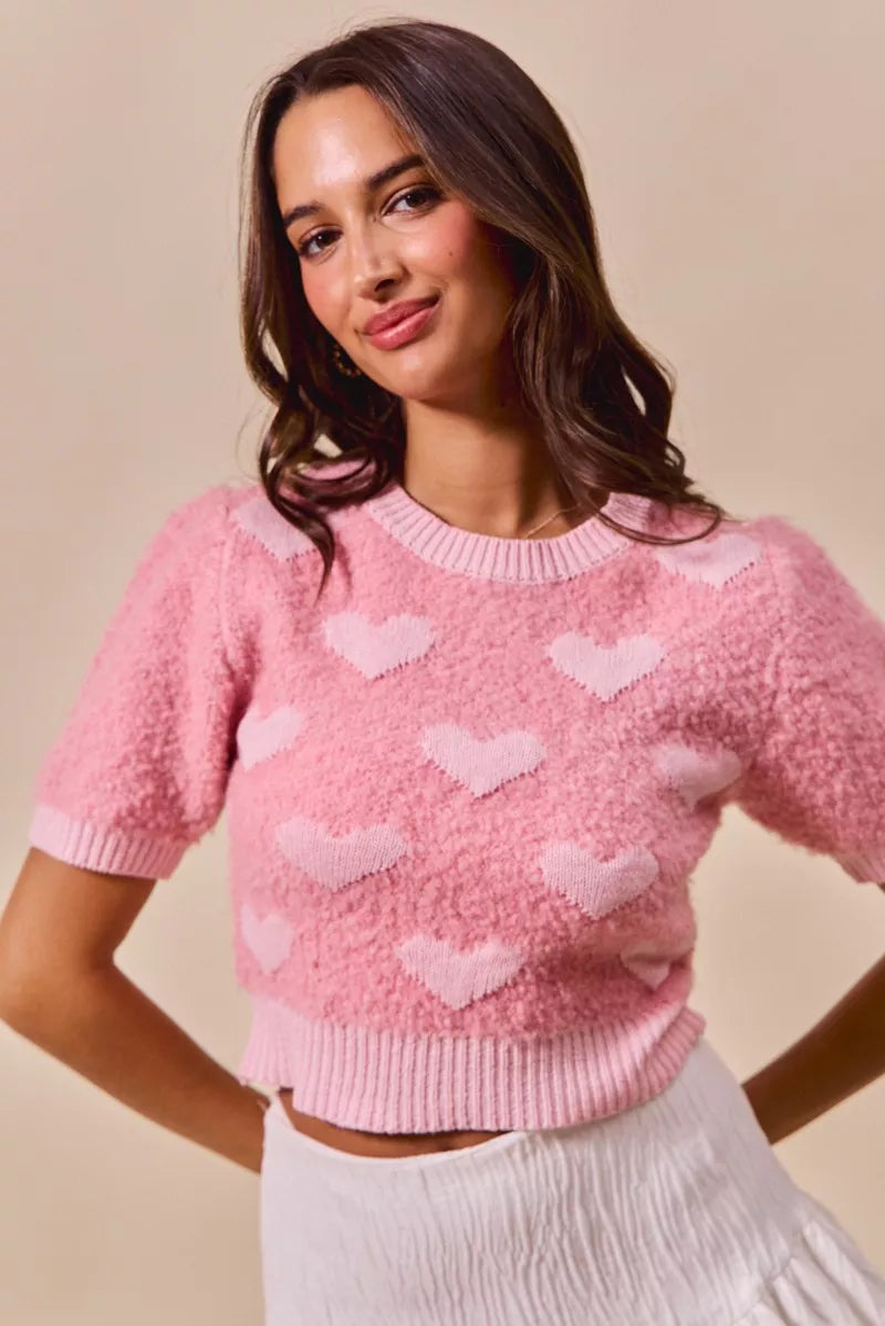 Pink cropped knit sweater with all-over heart pattern, crew neck, short sleeves
