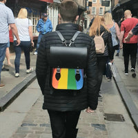 Black leather city backpack with rainbow Pride front, worn on back with shoulder straps