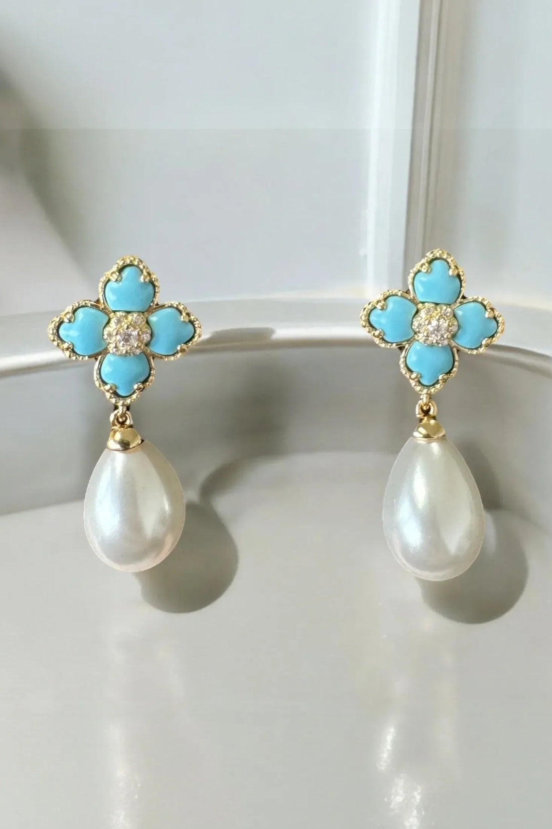 Pair of gold flower clover drop earrings with turquoise enamel and white pearl