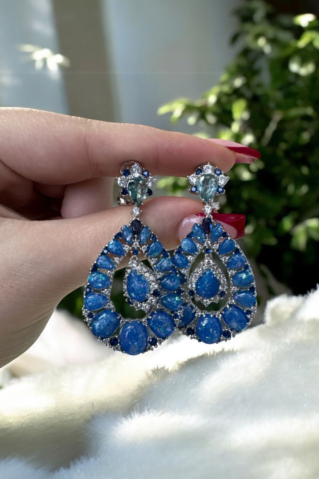 Blue teardrop drop earrings with clustered round stones on silver settings