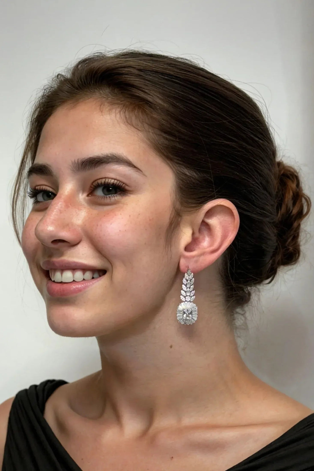 Silver-tone drop earrings with marquise clusters, worn on model’s ear