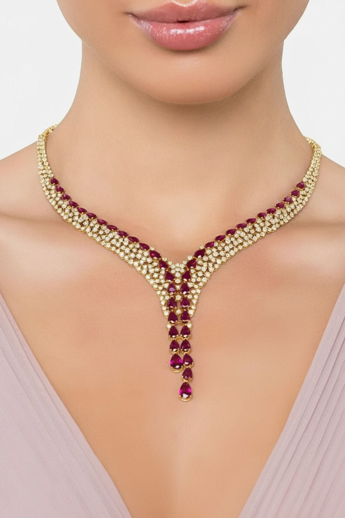 Gold-tone necklace with ruby red teardrop gemstones in a V-shaped drop