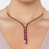 Gold-tone necklace with ruby red teardrop gemstones in a V-shaped drop