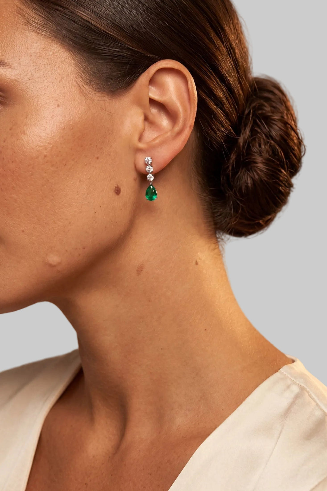 Silver triple-drop earrings with emerald-green pear drop and small crystal studs