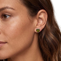 Silver heart stud earrings with peridot-green gemstone on ear
