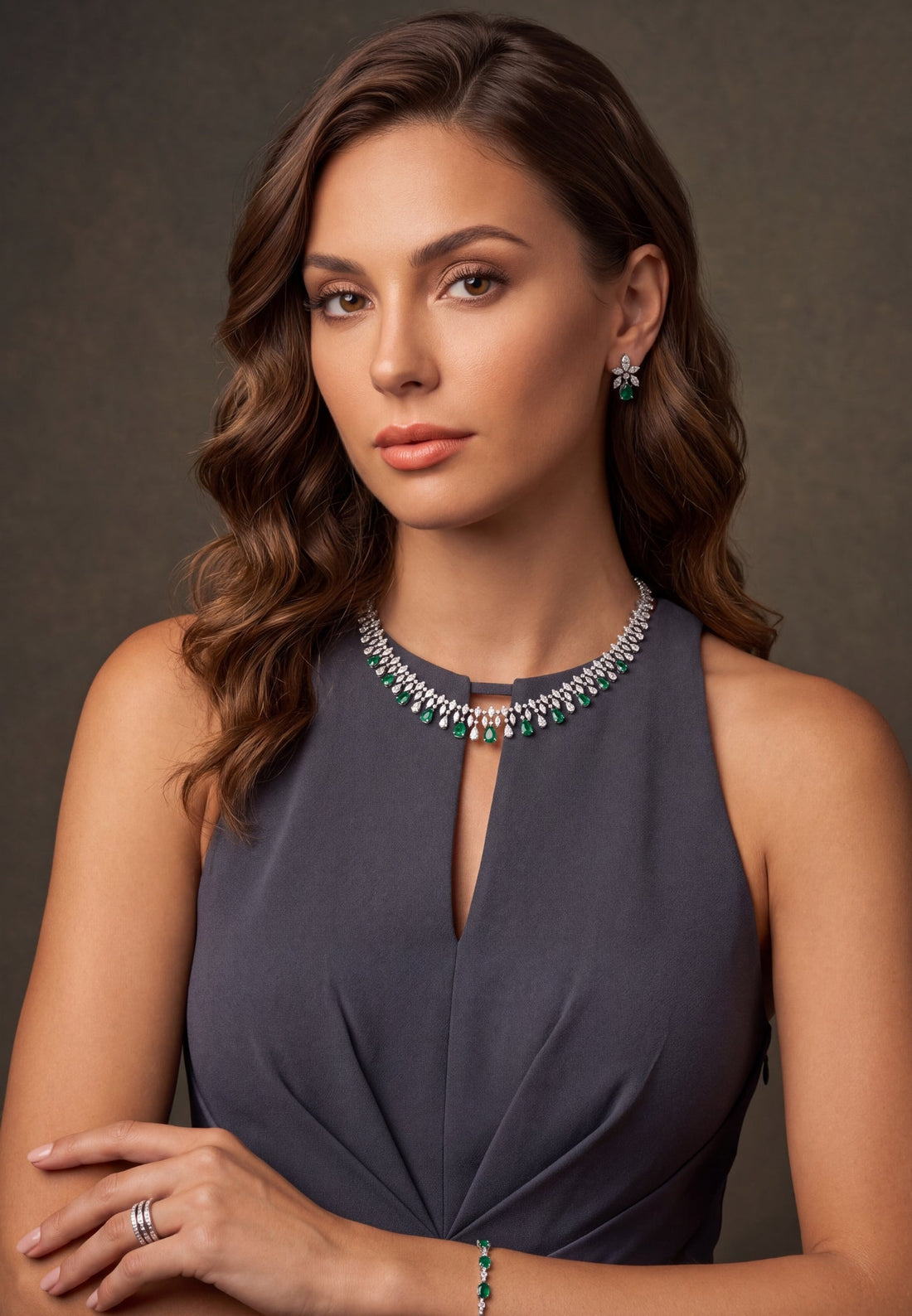 Silver-tone statement necklace with emerald-green drop stones, worn on model&