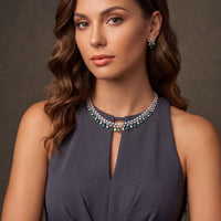 Silver-tone statement necklace with emerald-green drop stones, worn on model's neck