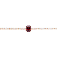 Gold tennis bracelet with oval ruby center stone