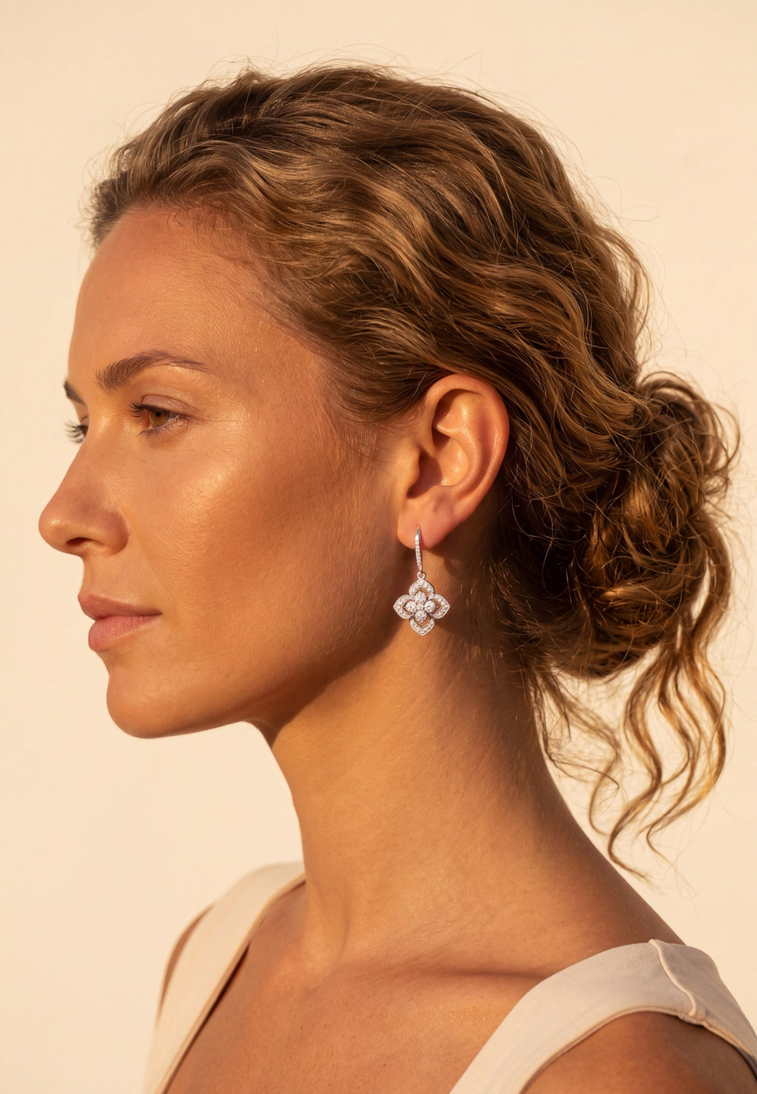 Silver CZ clover flower drop earrings on model, small dangling flower design