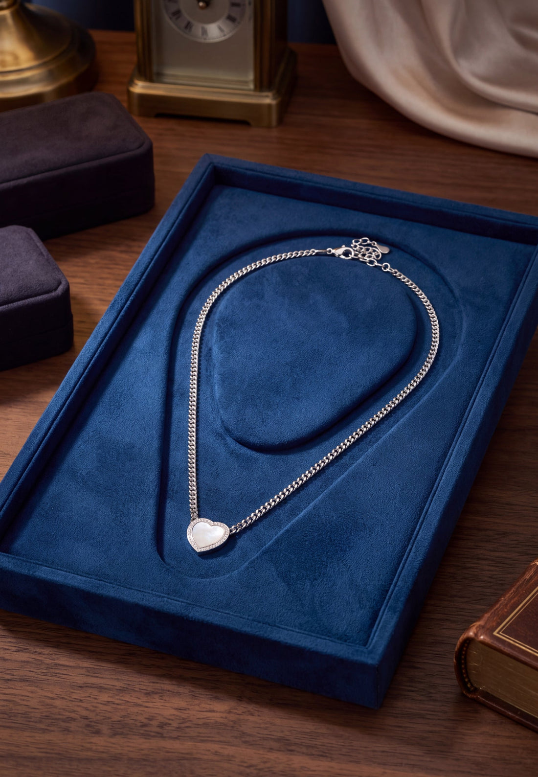 Heart mother-of-pearl silver necklace lying in blue jewelry box on tabletop