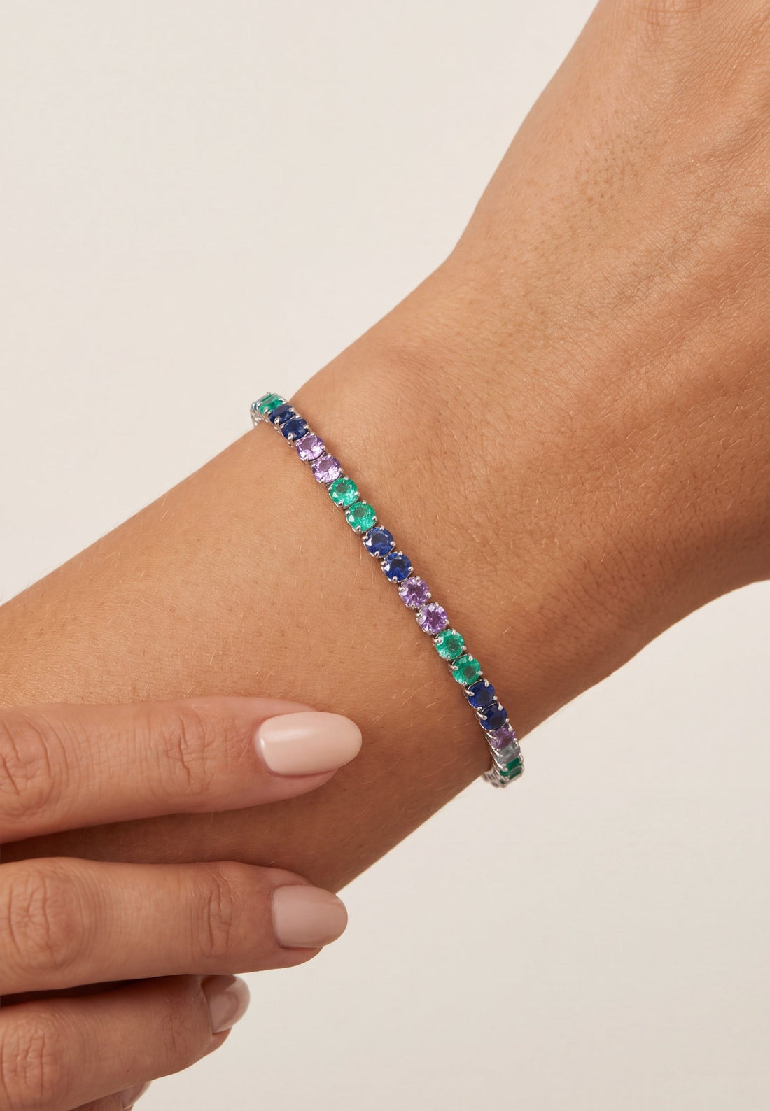 Silver tennis bracelet with multicolor gemstone row on wrist