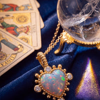 Gold heart pendant necklace with iridescent opal center and round sparkle stones