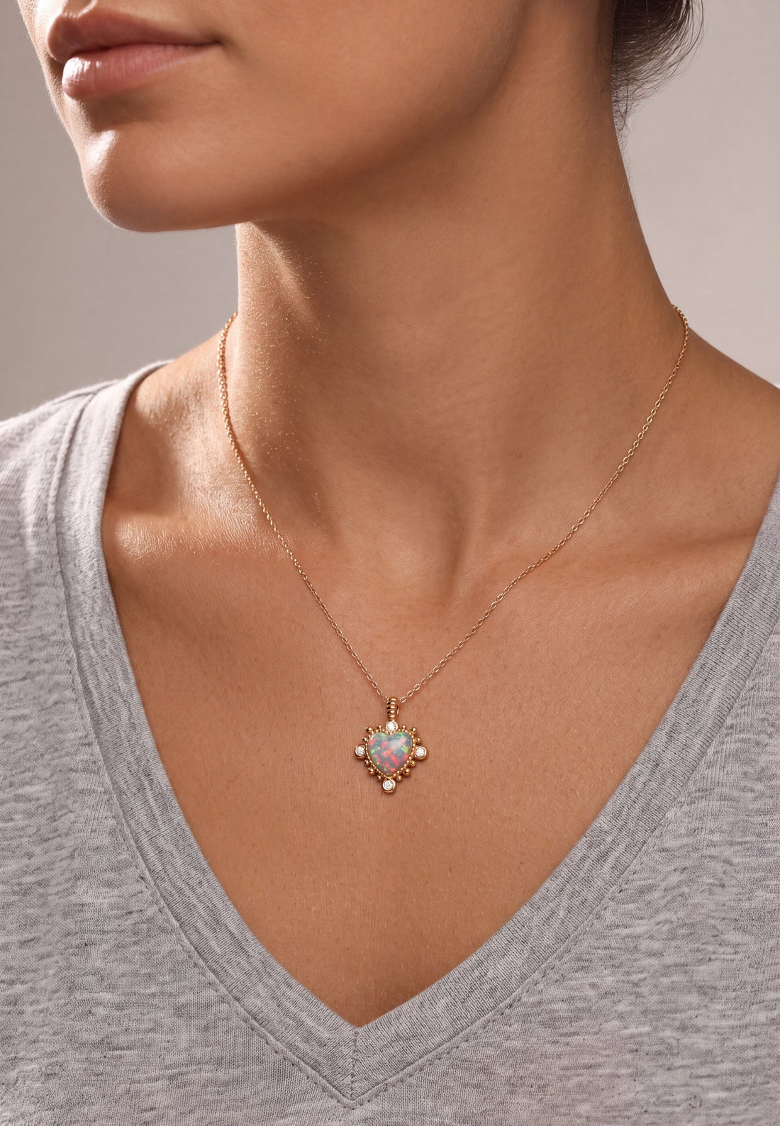 Gold opal-look heart pendant necklace on a model, worn on the neckline