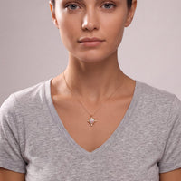 Gold heart pendant necklace with opal-like iridescent center on a model