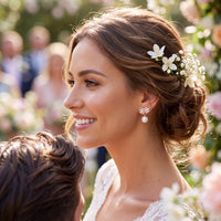 Gold-tone pearl drop earrings with crystal flower clusters, worn with bridal hairstyle
