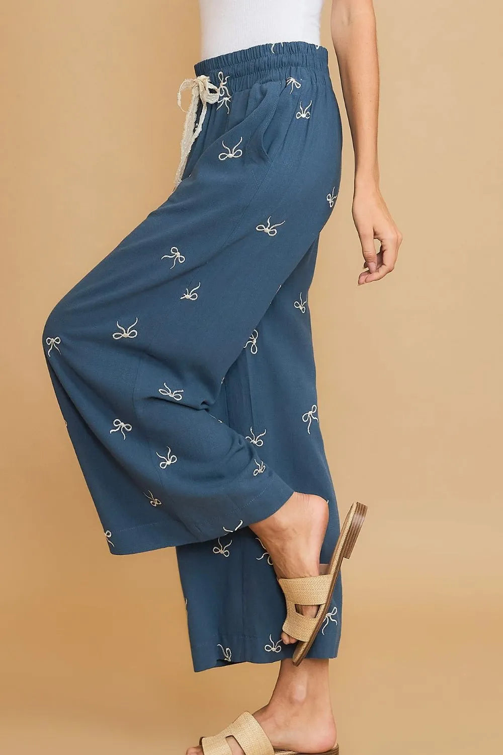 Dusty blue wide-leg drawstring pants with bow embroidery, side view