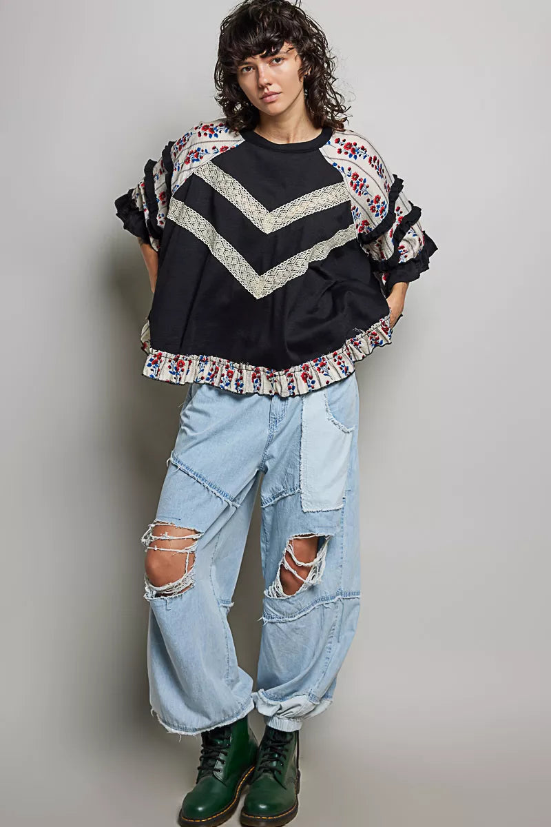 Black contrast lace knit top with floral ruffle sleeves and hem, round neckline