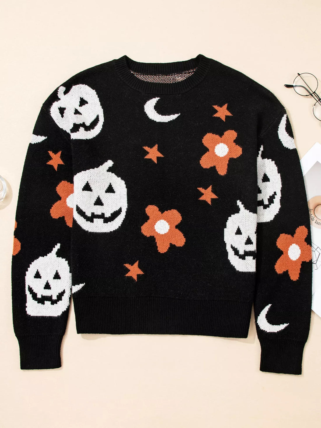 Black long-sleeve crewneck sweater with jack-o-lantern, flowers, bats, stars, and moons print