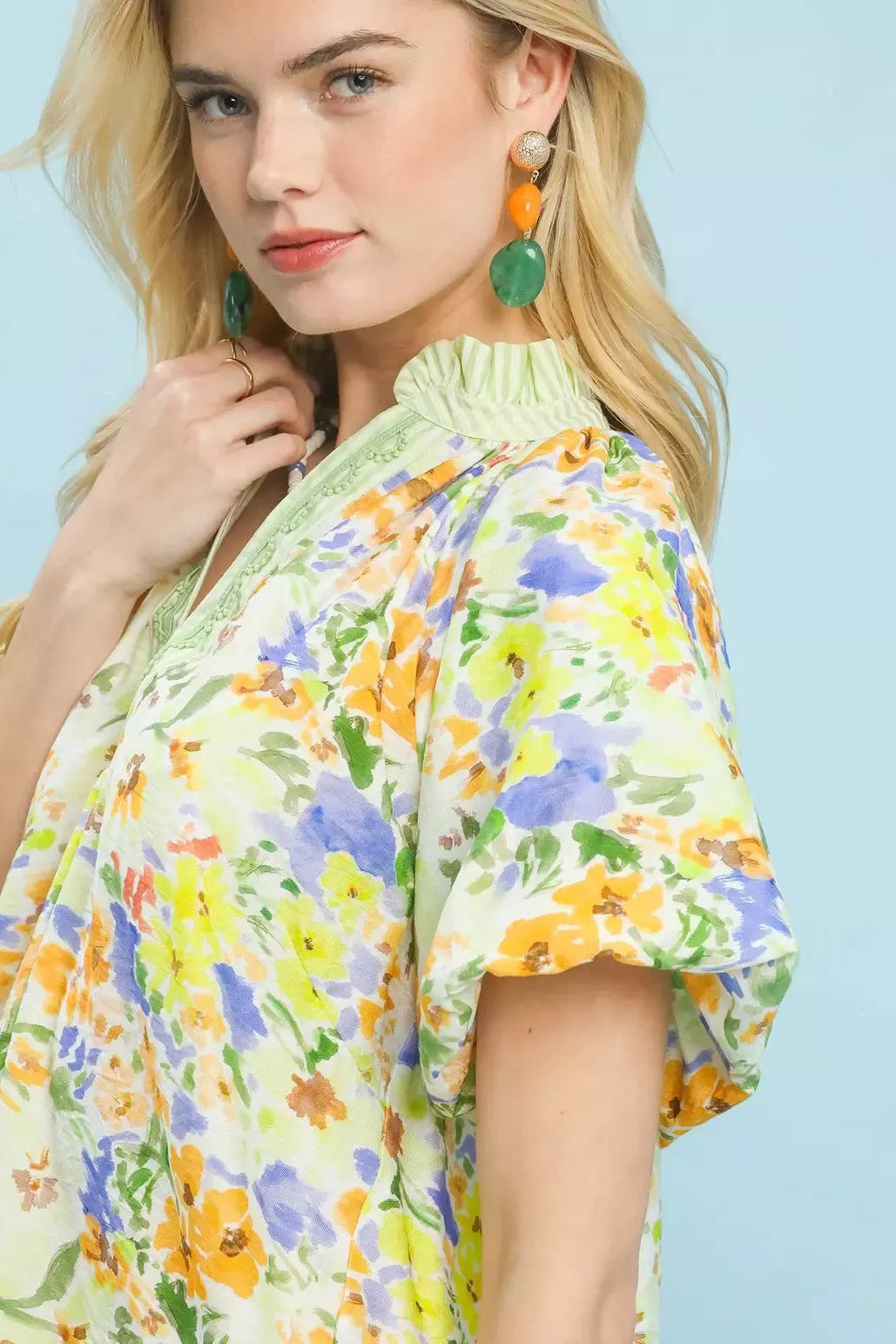Green watercolor floral blouse close-up with embroidered V-neck and puff sleeve cuff