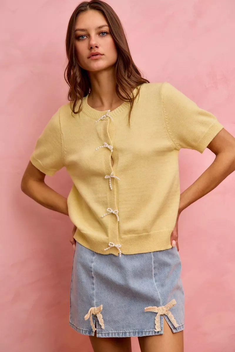 Light blue denim mini skirt with lace ribbon bow trim and frayed hem edge.