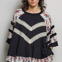 Black oversized knit top with round neck, contrast chevron lace, floral ruffle trims