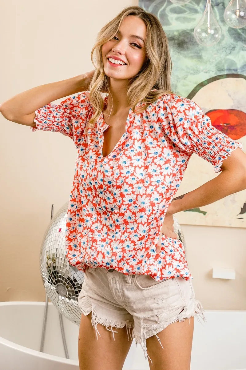 Orange floral V-neck top with smocked puff sleeves and relaxed, gathered fit