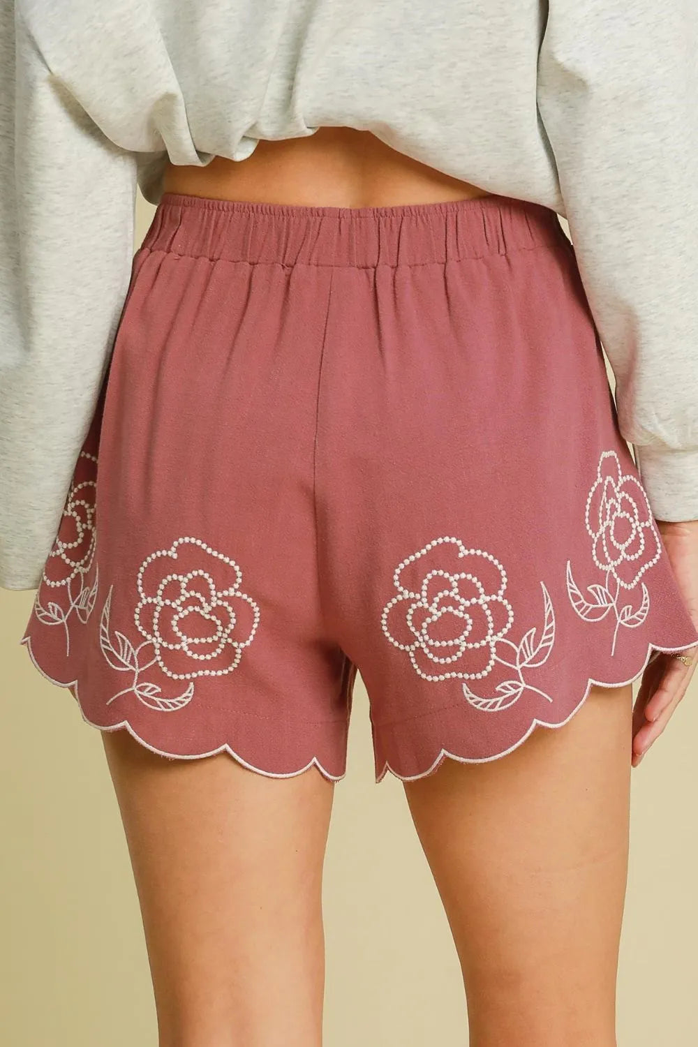 Dusty pink linen-blend shorts with floral embroidery, elastic waist, scalloped trim