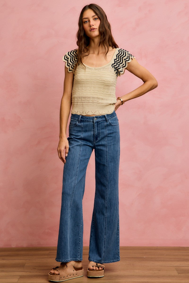 Oatmeal wavy textured knit top with flutter sleeves and zigzag black trim