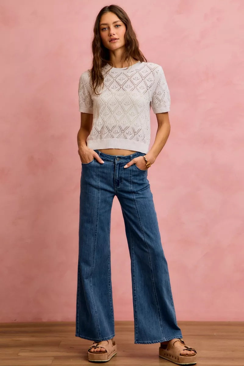 Mid-rise stretch denim jeans, full-body view with wide-leg flare and button fly