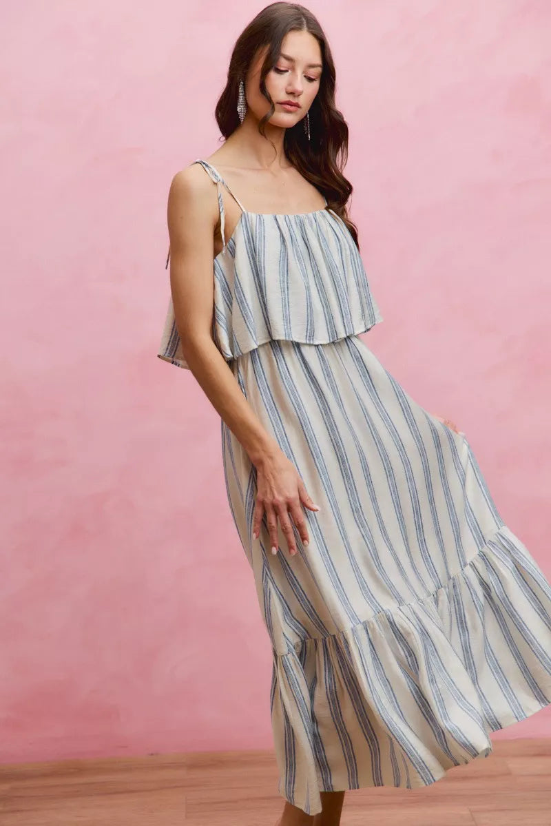 Side view of sleeveless striped midi dress with tiered ruffle hem and tie shoulder straps