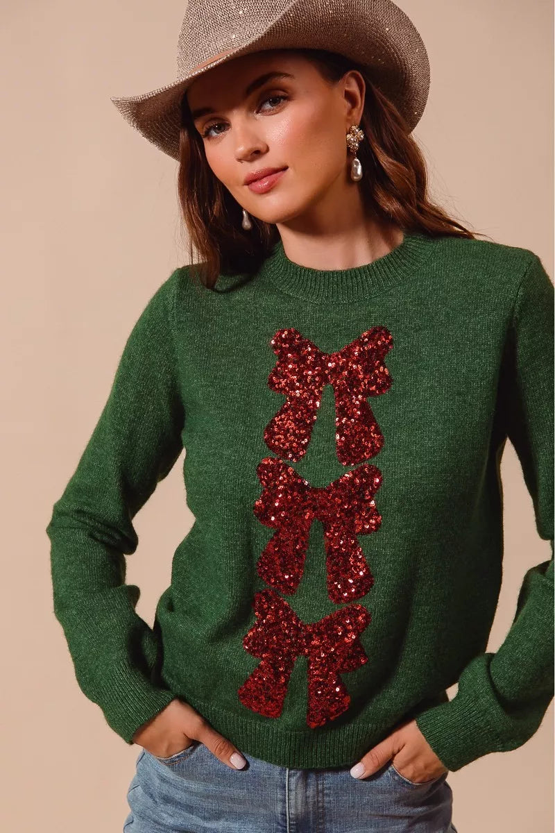 Hunter green Christmas sweater with red sequin bow ribbon detail at chest